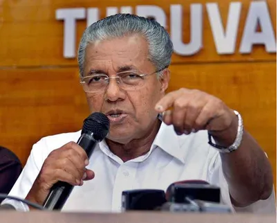 A formal portrait or press conference image of Kerala Sports Minister O.J. Janeesh speaking to reporters